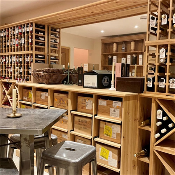 Large private wine room using solid pine racking in Hampshire